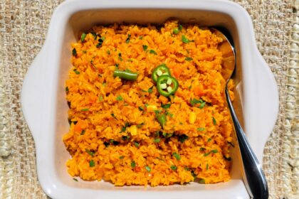 Mexican rice in dish with spoon and sliced jalapeno